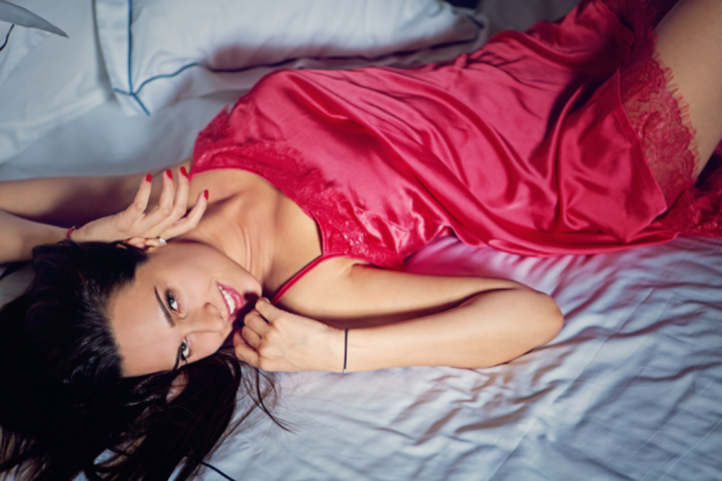 brunette mature woman photo while laying on bed smiling