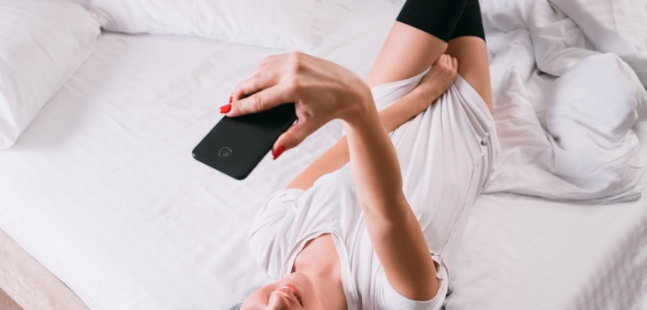 beautiful woman on the bed with phone