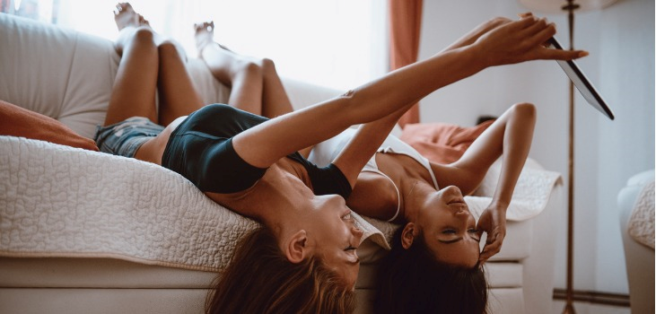 2 young girls on the couch playing