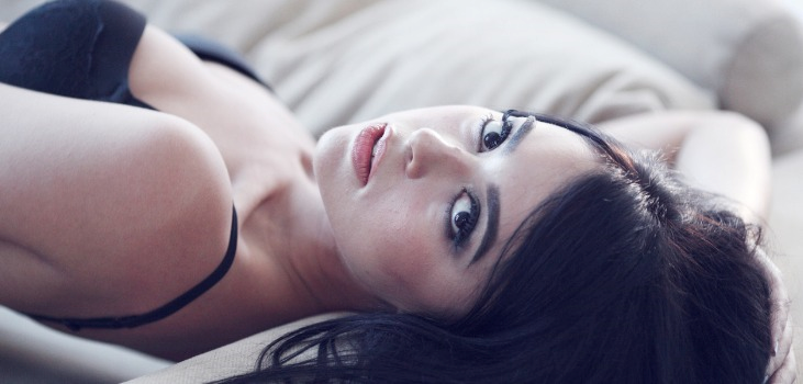 brunette mature sexy woman posing on bed